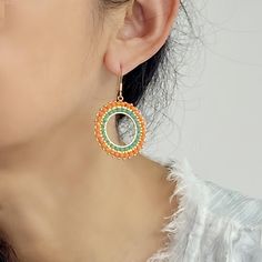 Add a pop of vibrant color to your ensemble with these stunning Orange hoop Boho style handmade earrings. The oversized circles feature intricate brick stitch beadwork using high-quality Miyuki Delica seed beads, creating a truly unique and eye-catching accessory. These big, bold earrings are perfect for those who love adding a touch of bohemian flair to their look. Stand out from the crowd with these one-of-a-kind statement earrings that are sure to turn heads wherever you go. Closure: Ear hook Diameter: 1.32 inches Quantity:1 pair Bohemian Hoop Beaded Earrings With Colorful Beads, Bohemian Beaded Hoop Earrings For Beach, Colorful Beaded Circle Earrings For Summer, Colorful Circle Beaded Earrings For Summer, Summer Colorful Beaded Circle Earrings, Beaded Bohemian Hoop Earrings, Bohemian Circle Earrings With Tiny Beads, Colorful Beaded Circle Earrings, Colorful Beads Hoop Earrings For Beach