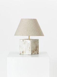 a lamp sitting on top of a white block