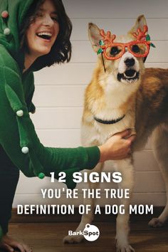 a woman petting a dog wearing sunglasses and a green hoodie with the caption 12 signs you're the true definition of a dog mom