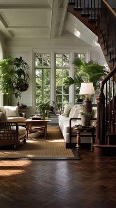 a living room filled with lots of furniture next to a stair case in front of a window