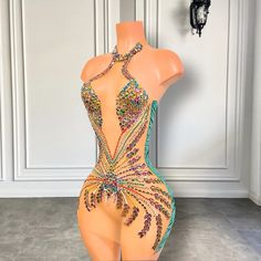 a mannequin is adorned with multicolored jewels and beads in front of a white wall