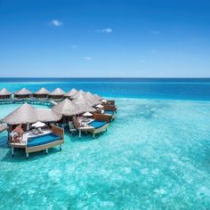 the water is crystal blue and has overhangs with thatched huts on it