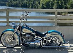 a blue and white motorcycle parked on the side of a bridge