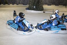 two people riding on snowmobiles in the snow