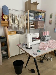 a sewing machine sitting on top of a table next to a trash can and other items