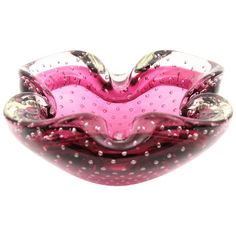 a pink and silver glass bowl with dots on it's sides, in the shape of a heart