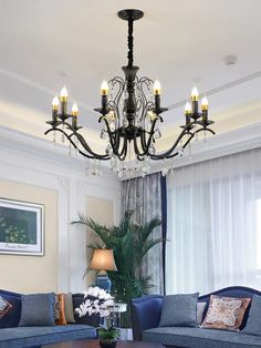 a living room filled with furniture and a chandelier hanging from the middle of it