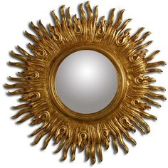 a gold sun shaped mirror on a white wall