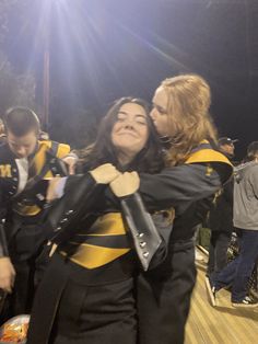 2 friends hugging at football game in band uniform. High School Best Friends Aesthetic, Shako Hairstyles Marching Band, Marching Band Boyfriend Aesthetic, Band School Aesthetic, Hairstyles For Marching Band, Marching Band Couple Aesthetic, High School Band Aesthetic, High School Friends Aesthetic, Band Couple Aesthetic