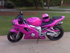 a pink motorcycle is parked on the sidewalk