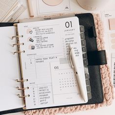 a planner and pen sitting on top of a desk