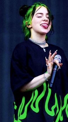 a woman with green hair holding a microphone