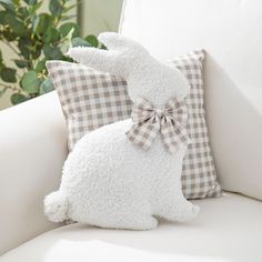 a white bunny pillow sitting on top of a couch