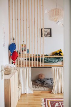 there is a bunk bed with curtains and pillows on the bottom level, next to a small child's bed