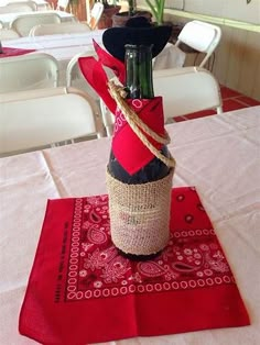 a wine bottle wrapped in twine and tied to a burlock on top of a table