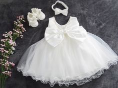 - A beautiful dress for your little princess + headband + shoes - Everything is made with love, simply breathtaking and graceful - Condition: New - Material: 100% polyester decorated with an elegant bow **- Available sizes - Gr. 56 - Gr. 62 - Gr. 68 - Gr. 74 - Gr. 80 - Gr. 86 - Gr. 92 - Gr. 98 - If you need a different size, just write to us - Please specify size **Please note - Sizes: +/-2 cm tolerance due to manual measurement. - The colors in the illustrations are never 100% like the picture.