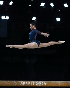 a woman is performing on the balance beam