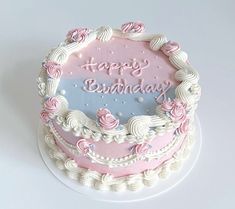 a birthday cake with pink and white frosting