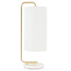 a lamp with a white shade on the base and a gold metal frame around it