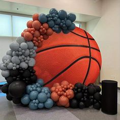 an orange basketball surrounded by black and white balloons