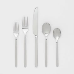 four forks, two spoons and one knife on a white surface