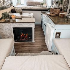 a living room with a couch and a fire place in the corner next to a bed