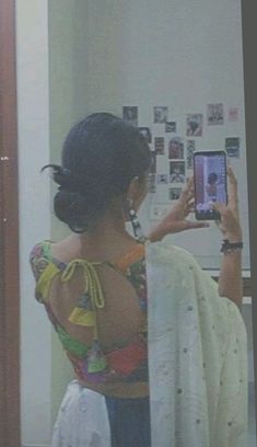 a woman taking a selfie in front of a mirror