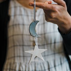 a person holding a metal star and moon decoration