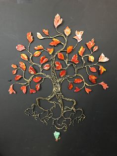 a metal tree with red and orange leaves