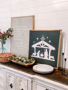 a nativity scene is displayed on top of a buffet table with plates and candles