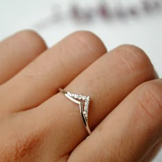 a woman's hand with a diamond ring on it