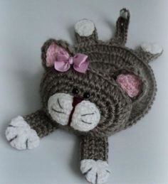 there is a crocheted stuffed animal that looks like a cat with a bow on its head