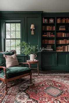 a living room with green walls and an area rug on the floor that has a chair in front of it