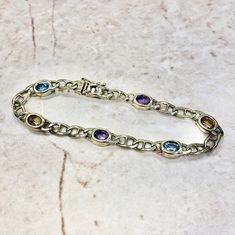 CLEARANCE - 40% OFF! Vintage 14 karat yellow gold multi gemstone link bracelet featuring 2 oval Amethysts, 2 oval Blue Topaz and 2 oval Citrines weighing approximately 2.5 CTTW. Each stone measures approximately 5.5 x 4.30 mm. L: 7 1/4 Inches / 18.41 cm. W: 6.57 mm. The bracelet weighs 11 grams. Birthstone: February/November/December. Condition: Very Good. Light scratches throughout metal. - Free insured shipping in the US. - International shipping available. Note: This item has been appraised a Amethyst Yellow Gold Bracelets With Gemstones, Luxury Polished Gold-colored Sterling Silver Bracelet, Edwardian Style Engagement Ring, Luxury Adjustable Citrine Bracelet, Vintage Oval Multi-stone Bracelets, Vintage Multi-stone Amethyst Jewelry, Topaz Bracelet, December Birthstone Jewelry, Gemstone Rings Vintage