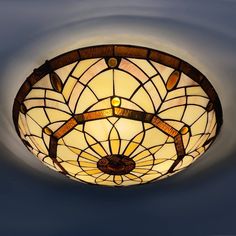 a stained glass ceiling light hanging from the ceiling in a room with blue walls and flooring