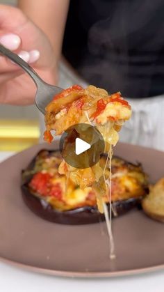 a person holding a fork with some food on it and dipping sauce over the top