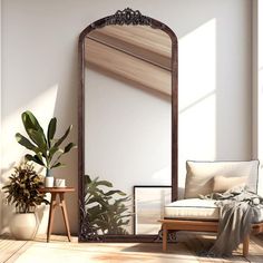 a large mirror sitting on top of a wooden floor next to a chair and potted plant