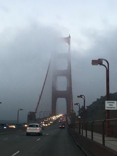 cars driving over the golden gate bridge on a foggy day