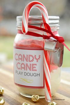 candy cane play dough in a jar with gold candies on the table next to it