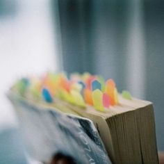 an open book with colored paper stuck to it