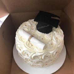 a cake in a box with a graduation cap and diploma on top that has been decorated