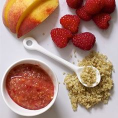 an apple, strawberries, granola, and yogurt on a cutting board