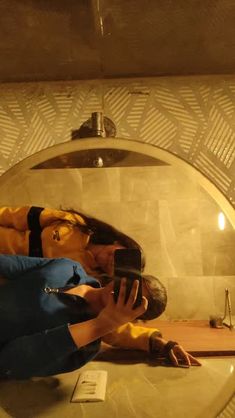 a woman taking a selfie in front of a mirror with her reflection on the wall