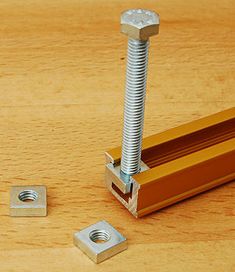 an image of a screw and bolt on a wooden table with two bolts in the middle