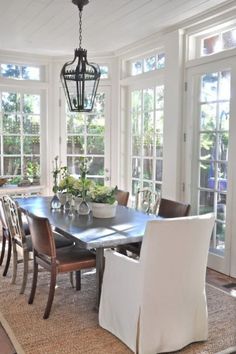 a dinning room table and chairs in front of large windows