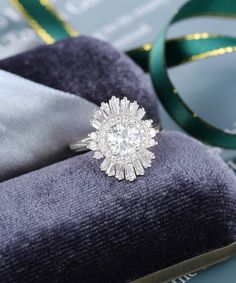 an engagement ring sitting on top of a piece of cloth