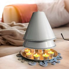 a lamp that is sitting on top of a table with candles in front of it