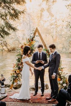 a couple getting married in front of a lake