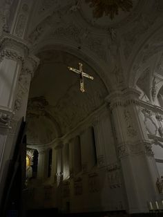 a cross hanging from the ceiling in a church