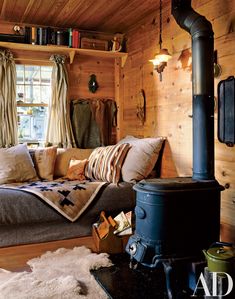 a living room filled with furniture and a fire place in front of a wooden wall